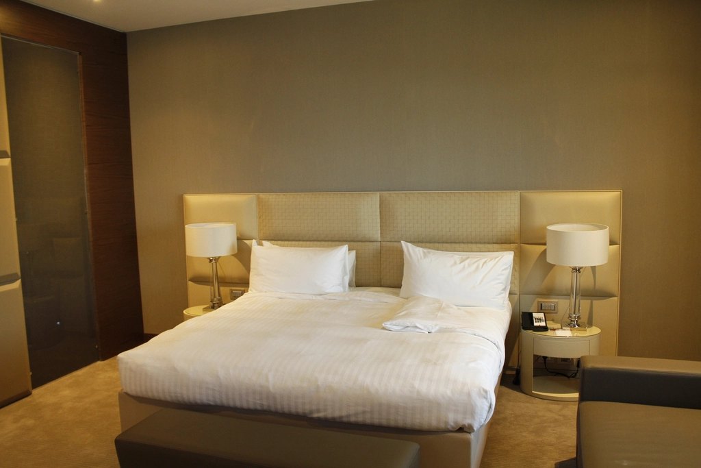 Hotel-style divan bed with white linens and upholstered headboard