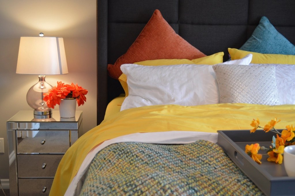 Styled upholstered divan bed with cushions and bedside lamps